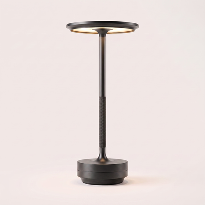 Eclara Ilumina cordless table lamp in matte black, flat disc head with warm LED, knurled stem and stepped base