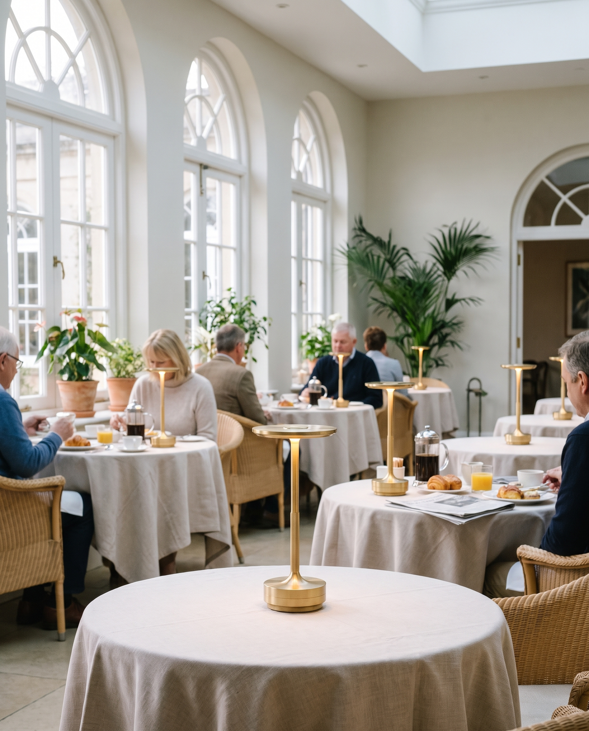 Eclara Ilumina cordless lamps on breakfast tables in a bright hotel orangery in the morning
