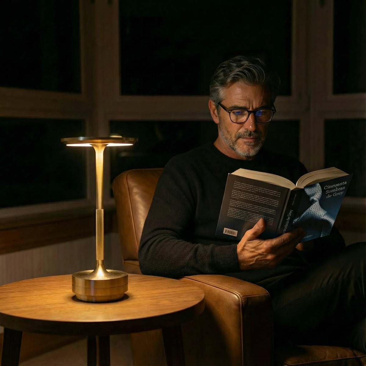 Gold Eclara Ilumina rechargeable cordless table lamp lighting a quiet reading moment in a premium living room
